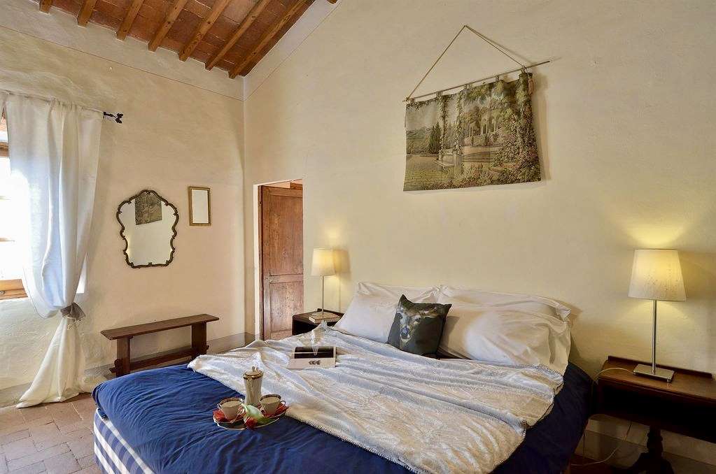 Another view of the small bedroom showing the window and bathroom door.